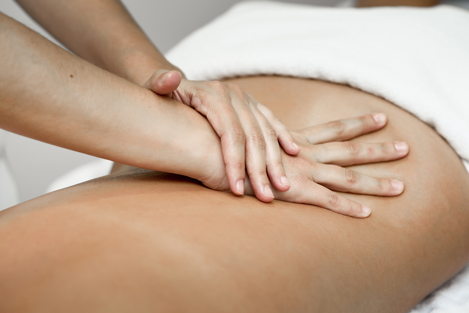 professional female physiotherapist giving shoulder massage to blonde woman