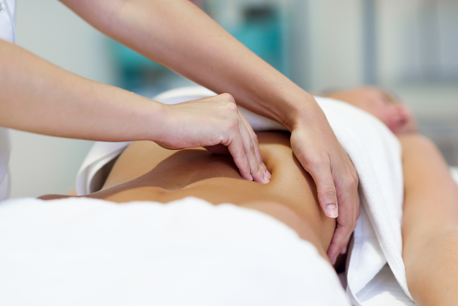 professional female physiotherapist giving shoulder massage to blonde woman